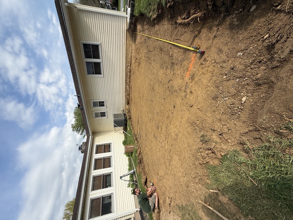Bare dirt backyard before patio installation